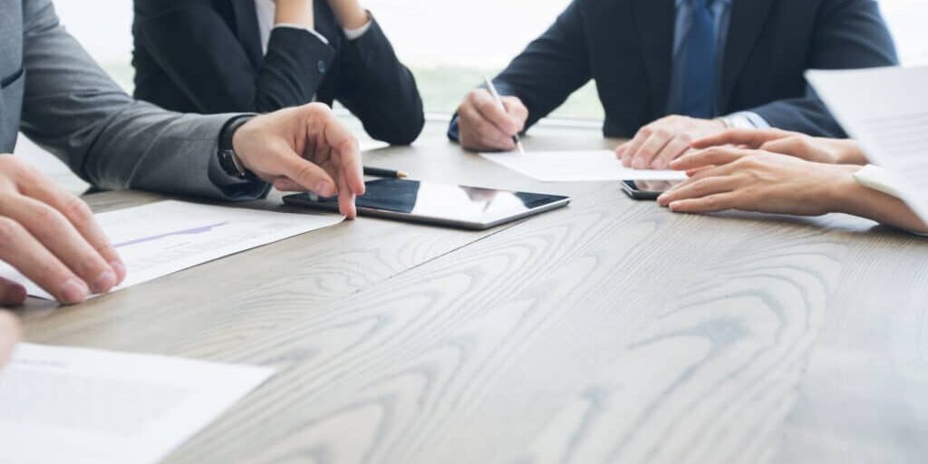 Business people work with documents and computers at office table close up